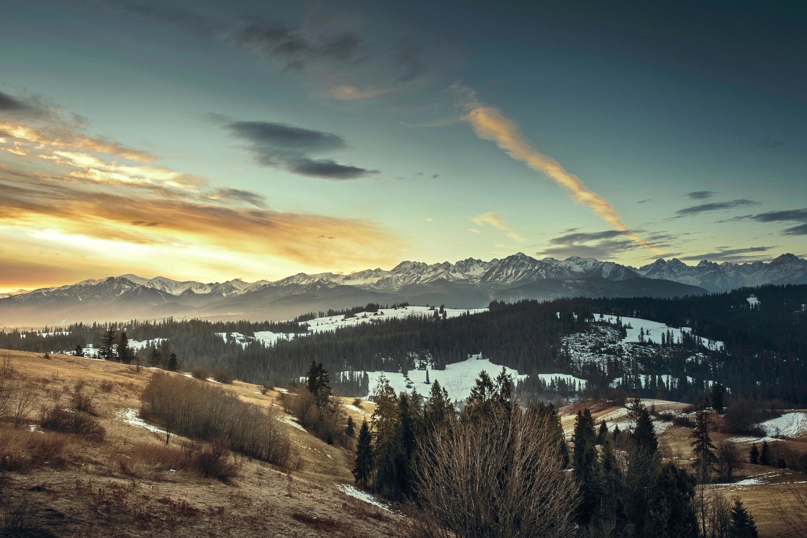 Montanhas cobertas de neve e árvores com um pôr do sol ao fundo (inverno, nuvem, montanha, neve, árvore)