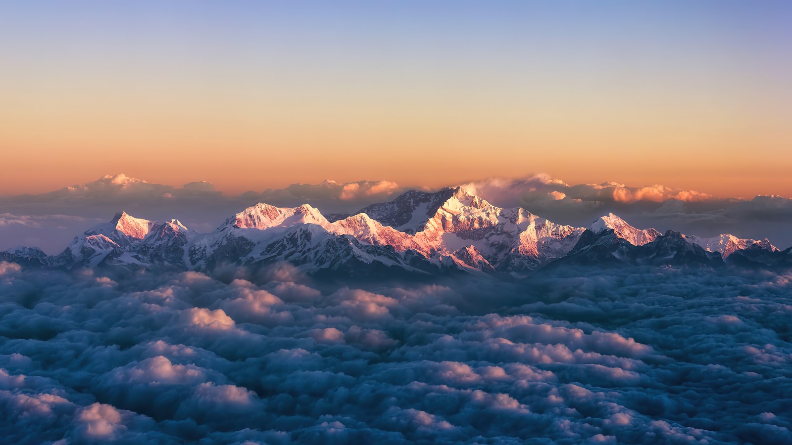 Vue sur une chaîne de montagnes avec des nuages en dessous (nuage, mer de nuages, lever de soleil, montagne, paysage)