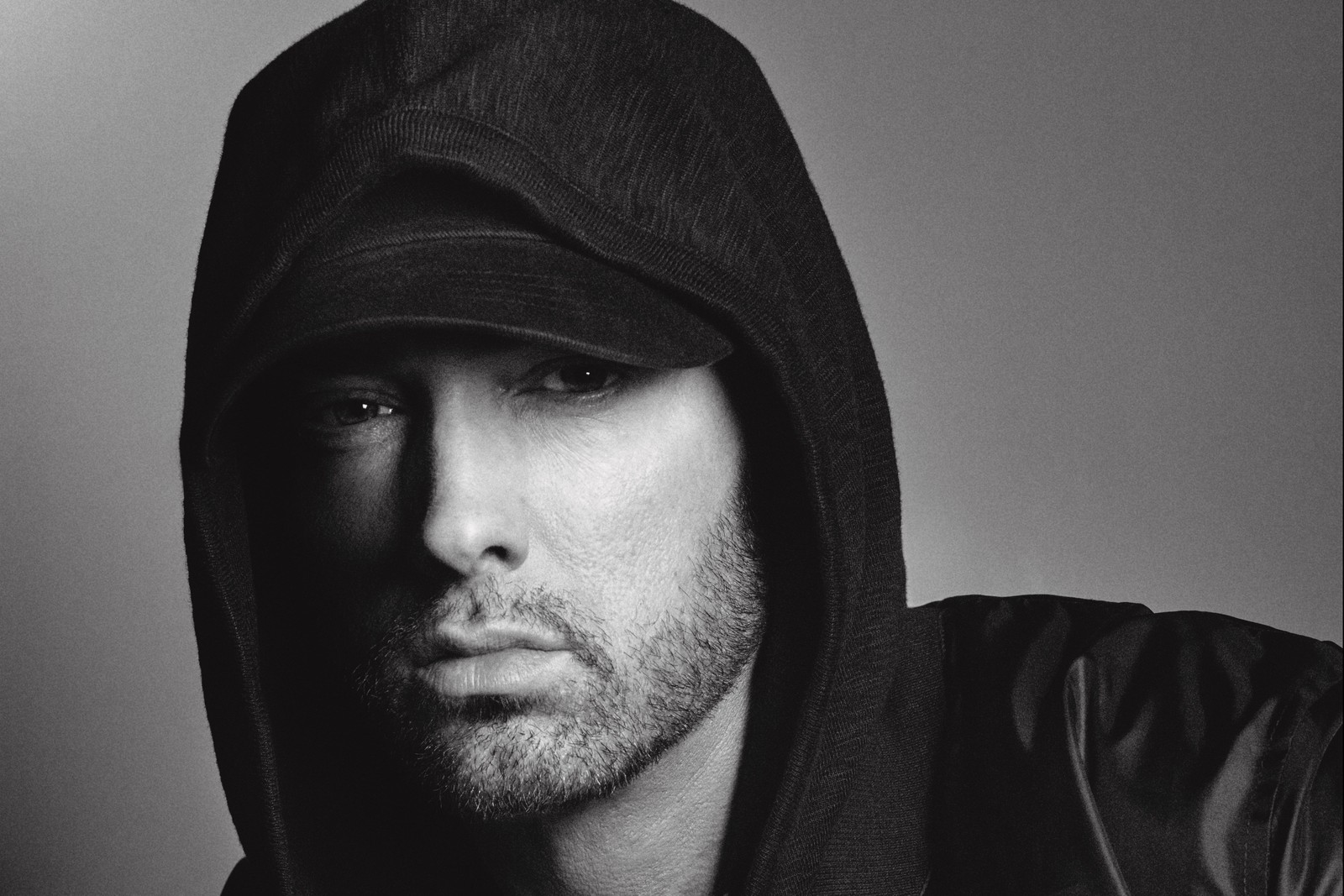 Homem árabe em moletom e jaqueta de couro posando para uma foto (eminem, rapper, kamikaze, concerto, rosto)