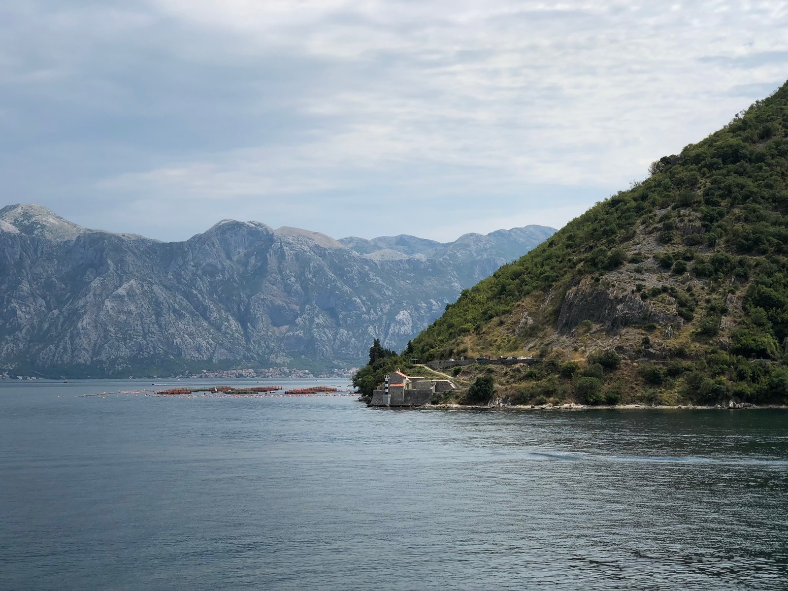 Mountains and a body of water with a small house on top of it (coast, body of water, mountainous landforms, water resources, water)