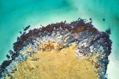 Vista aérea de la playa Ytresand: Costa vibrante con afloramientos rocosos y aguas oceánicas de un azul prístino