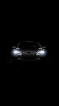 Sleek Black Audi: Illuminated Car Front in Dark Background