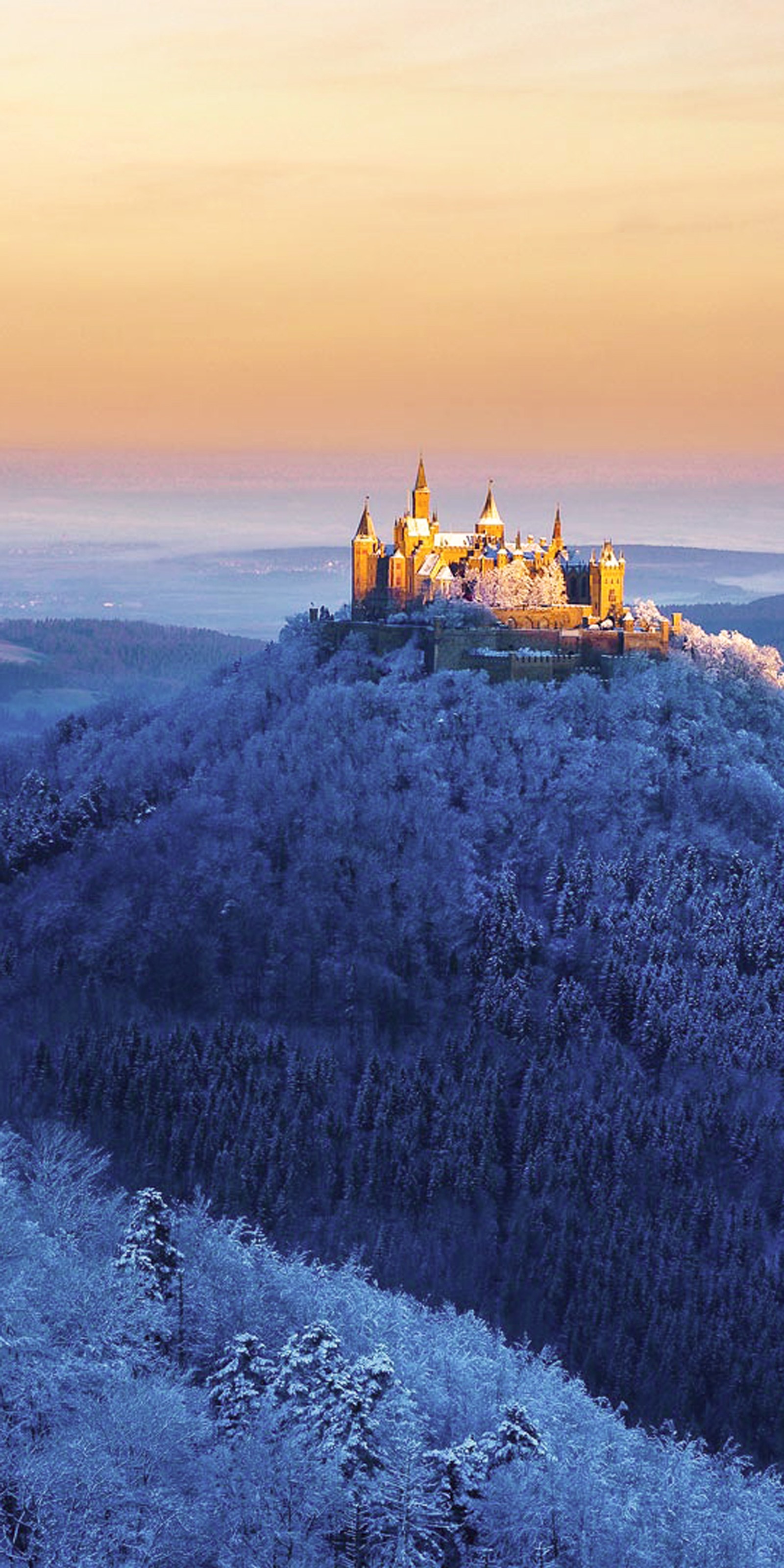 Eine burg auf einem hügel mit einem schönen sonnenuntergang im hintergrund (burg, hohenzollern, landschaft)