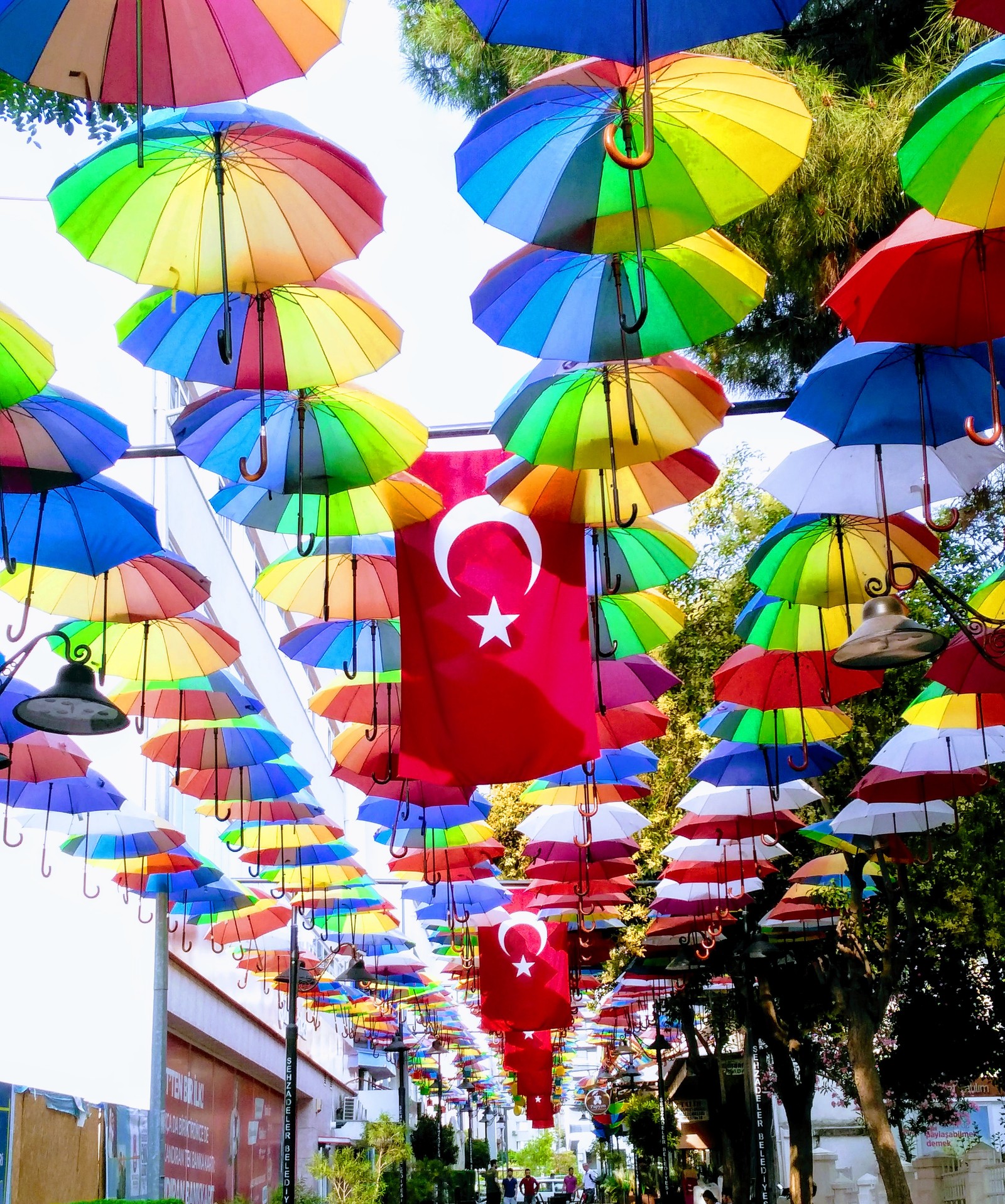 Viele bunte regenschirme hängen von der decke auf der straße (fragesteller, bayrak, doga, fahne, rengarenk)