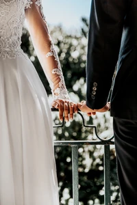 Intimer Moment: Braut und Bräutigam halten sich an ihrer Hochzeit die Hände