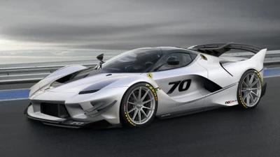 Ferrari FXX K в элегантном серебре, демонстрирующий свою аэродинамическую форму и гоночное наследие на фоне драматичного облачного пейзажа.