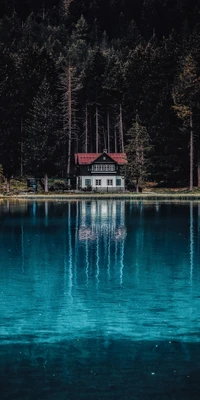 Réflexion tranquille d'une maison entourée d'arbres luxuriants et d'eaux bleues