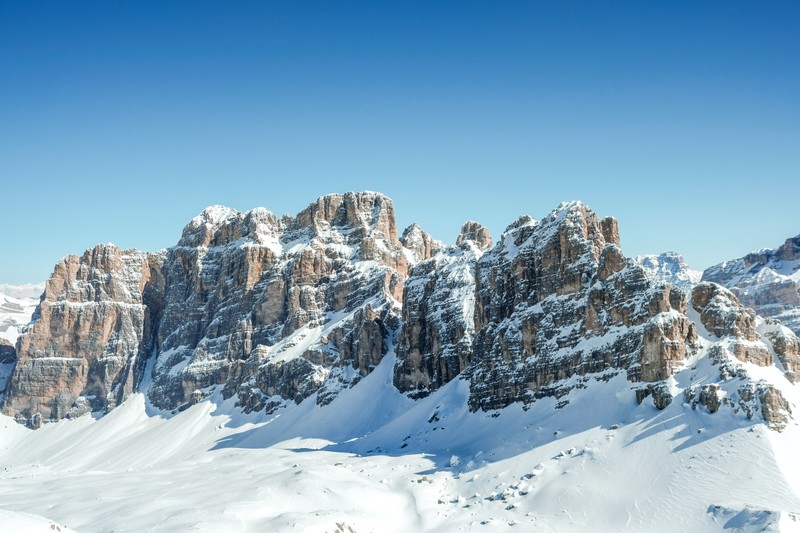 Горы, покрытые снегом, и сноубордисты в солнечный день (доломиты, dolomites, ясное небо, горный хребет, солнечный день)