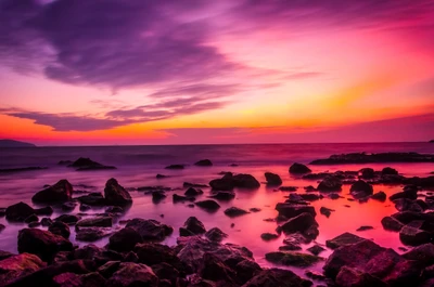 Sérénité crépusculaire : Coucher de soleil vibrant sur la côte rocheuse