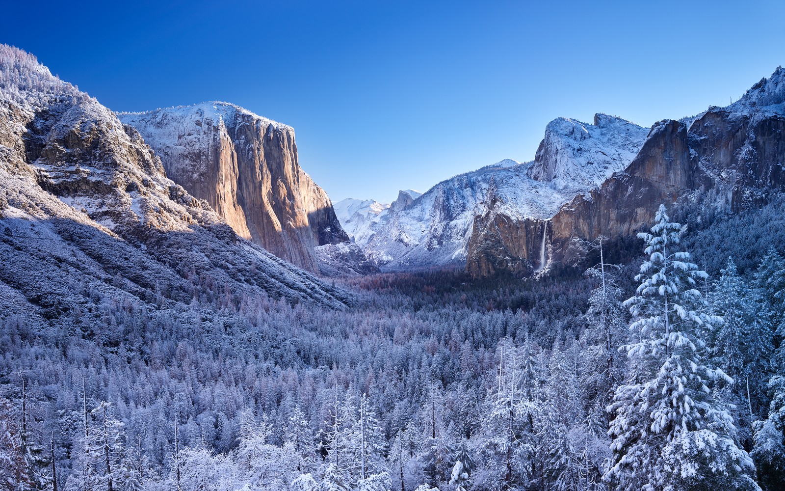 Une vue de la vallée en hiver avec de la neige au sol (parc national de yosemite, hiver, montagnes, jour ensoleillé, paysage)