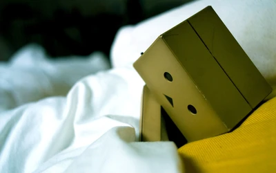 Danboard Robot in Bed: A Close-Up of Sadness Amidst Green and Yellow