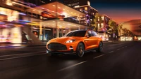 Aston Martin DBX707: SUV de rendimiento lujoso en un vibrante paisaje urbano al anochecer