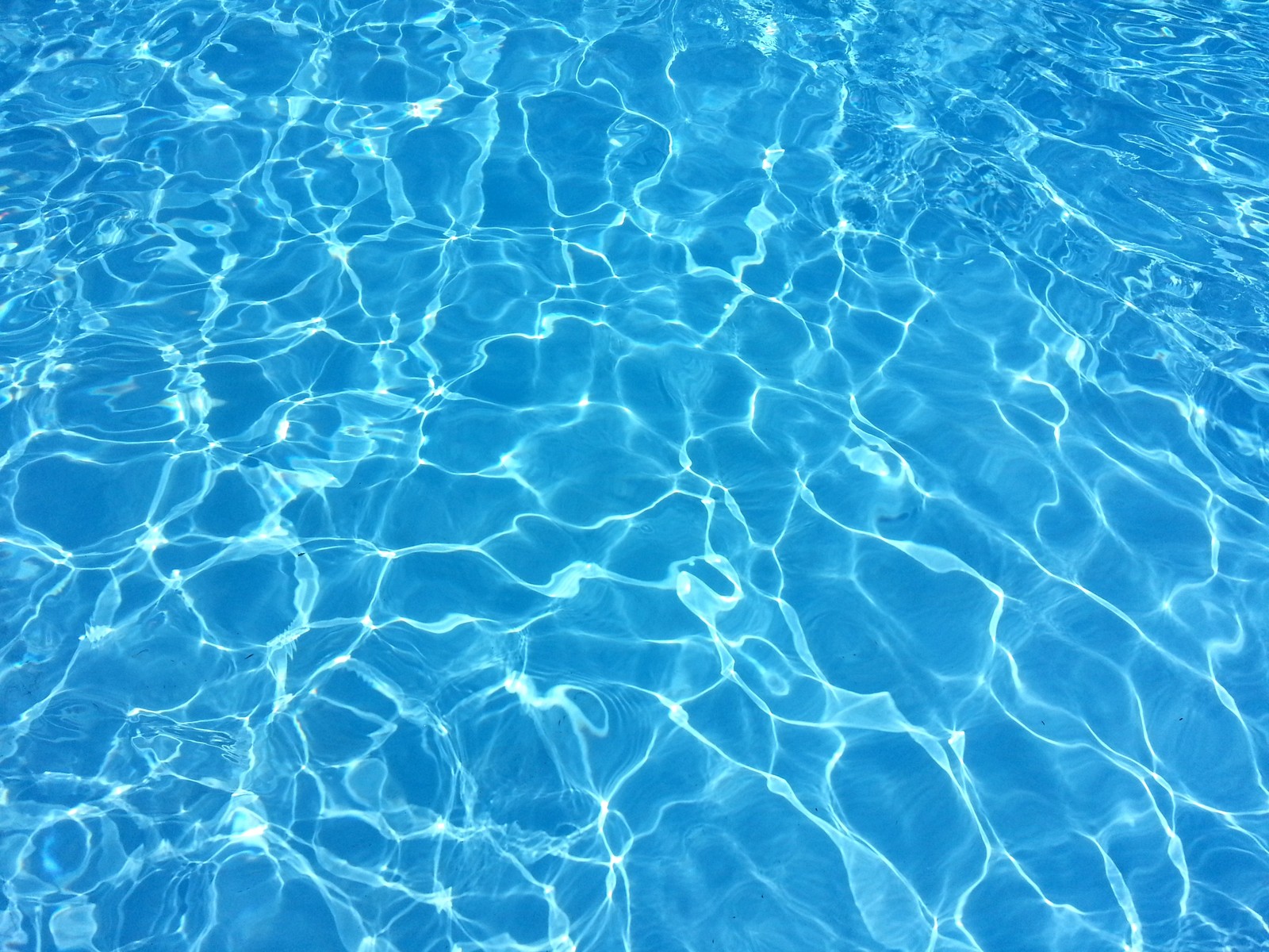 A close up of a pool with a blue water surface (swimming pool, swimming, blue, water, aqua)