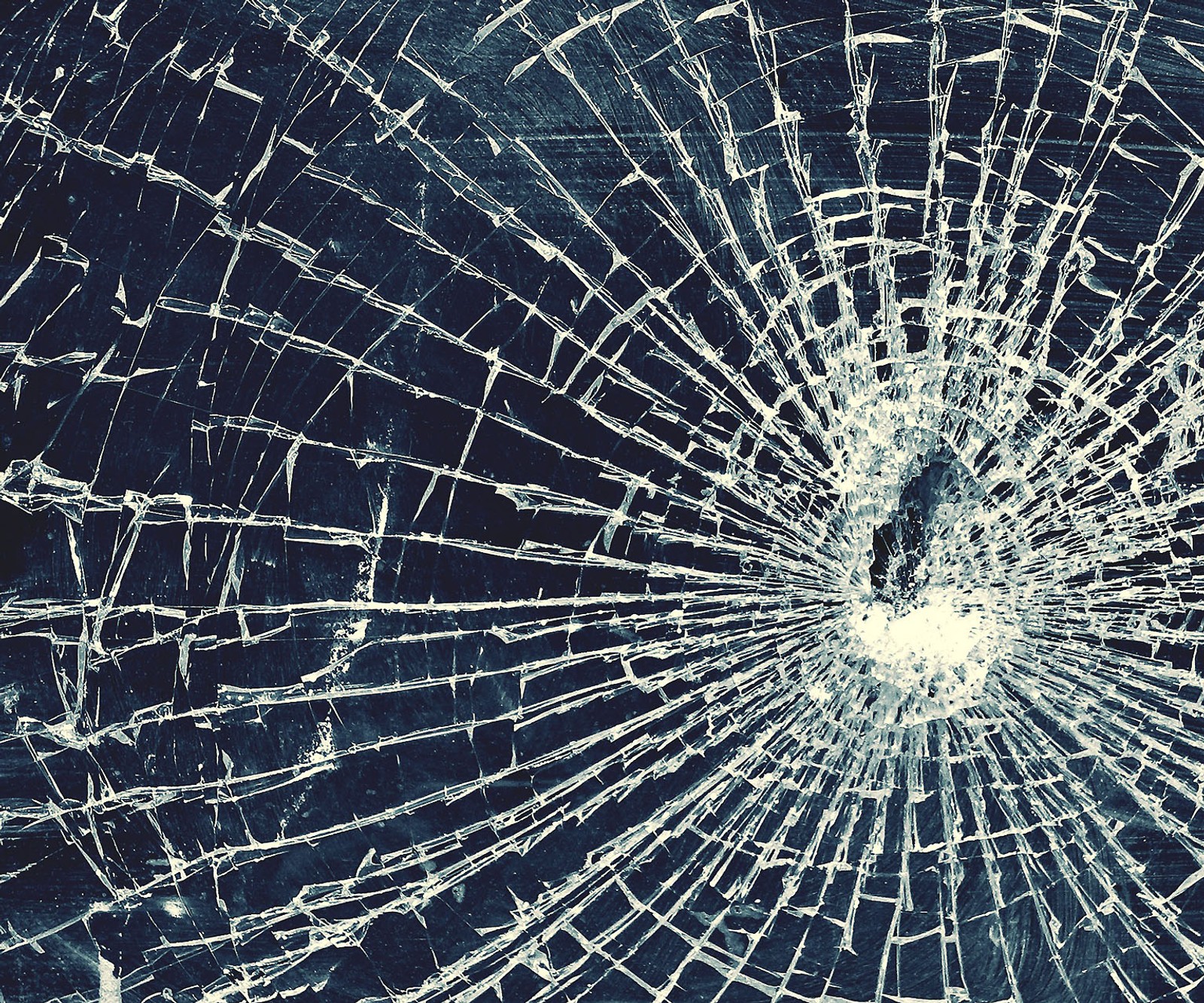 A close up of a broken glass window with a hole in it (broken glass, glass)