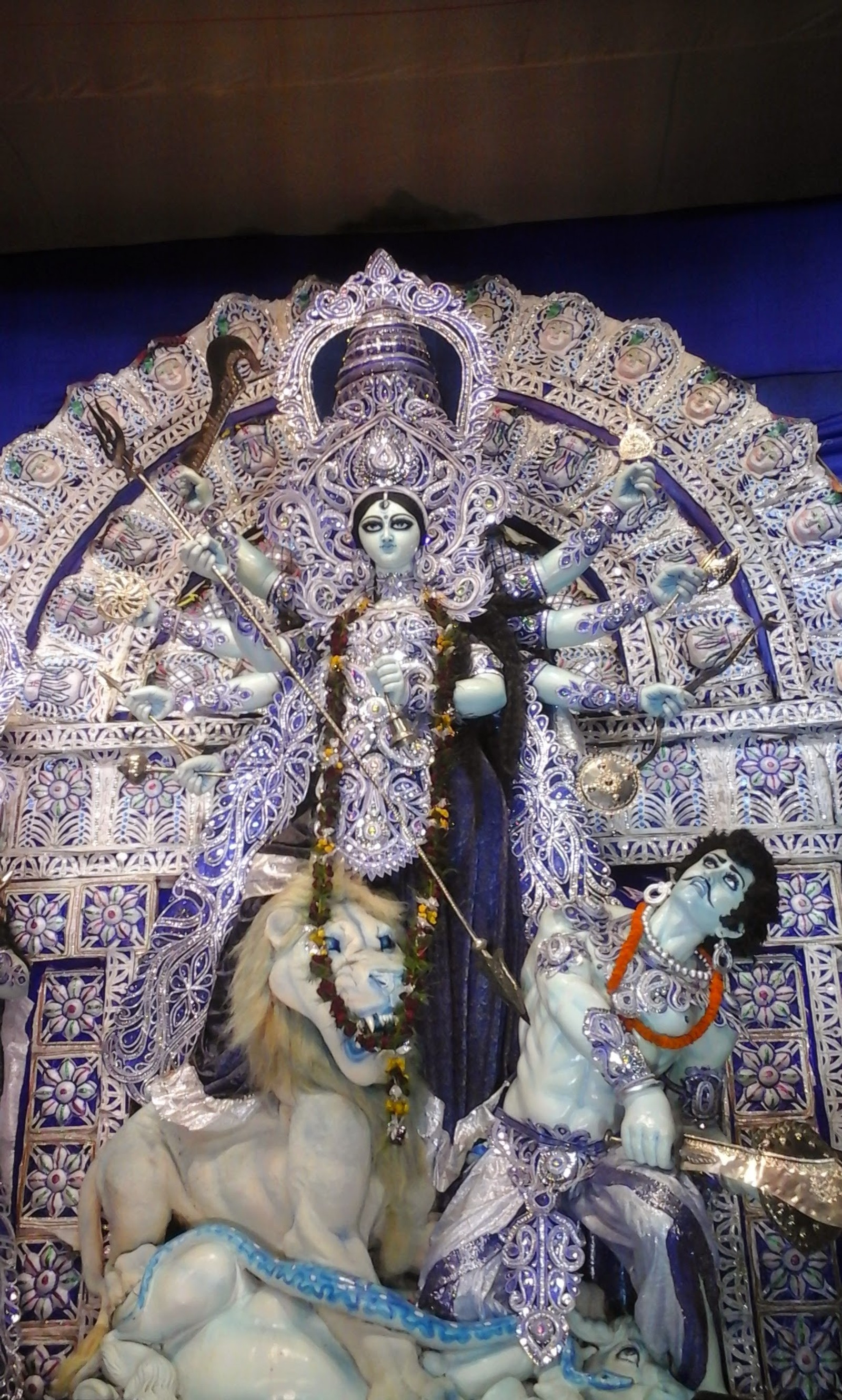 Imagen arafed de una estatua de una mujer y un hombre en un traje azul y blanco (durga puja, calcuta, shobhabazar)