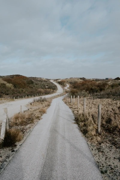 Winding Highland Road unter einem bewölkten Himmel