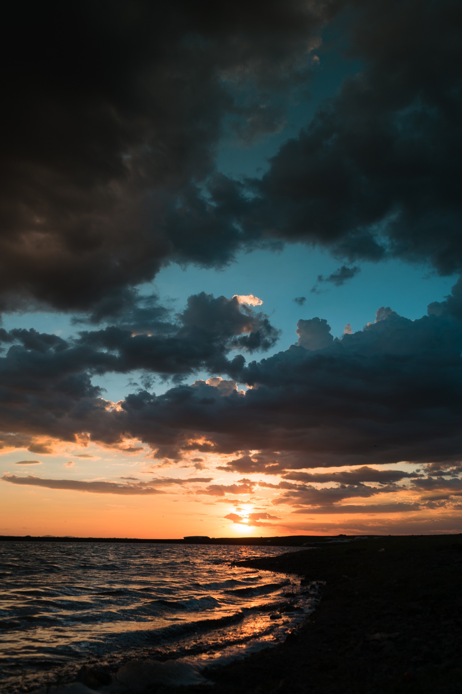 Vue d'une plage avec une personne debout sur le rivage (coucher de soleil, android, crépuscule, téléphone, mer)