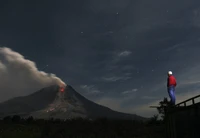 Nachtansicht des ausbrechenden Mount Sinabung unter einem sternenklaren Himmel