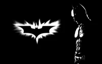 Silhouette de Batman contra un llamativo logo monocromático, que encarna la esencia de la oscuridad y el heroísmo.