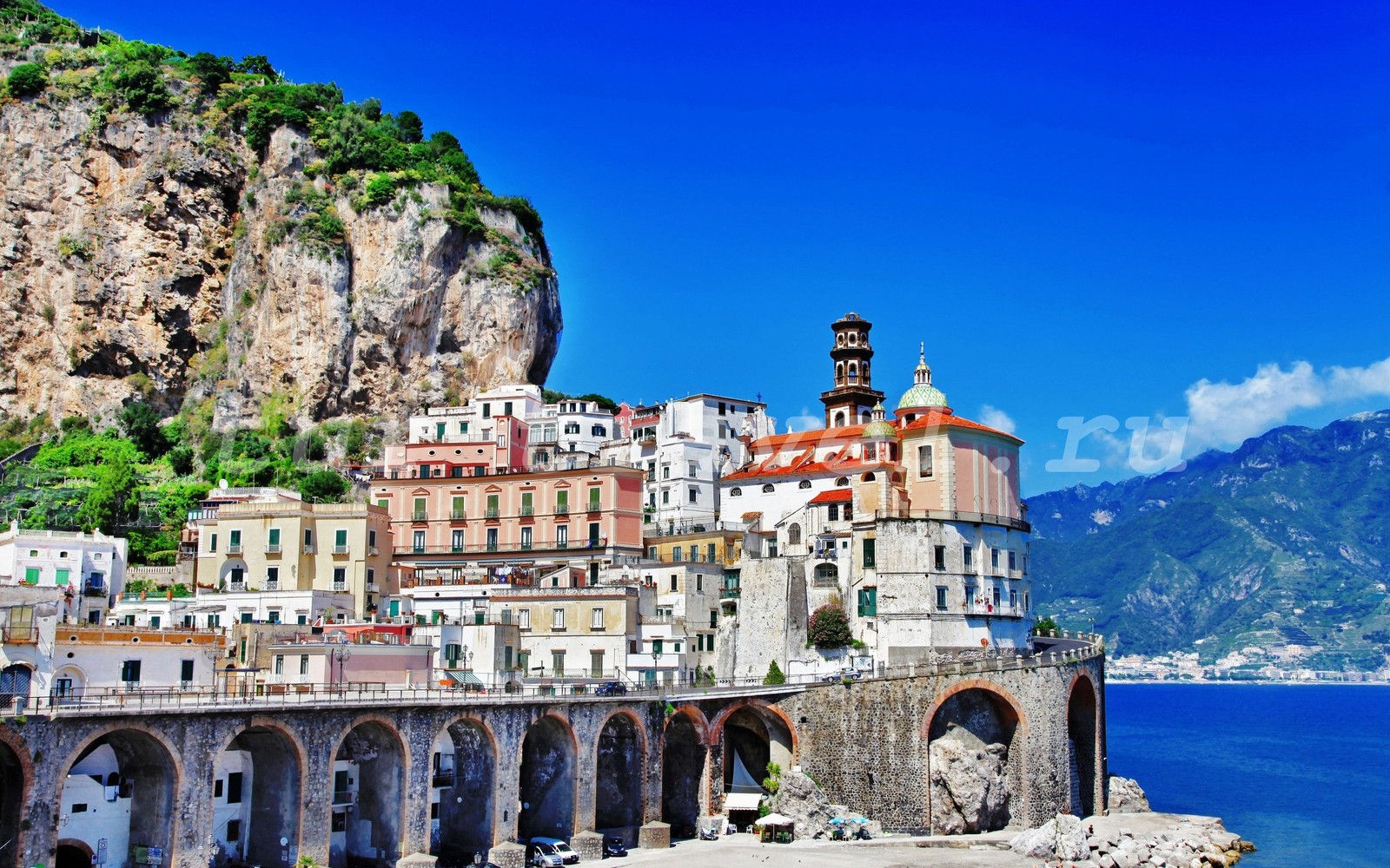 Uma vista de uma cidade na beira de um penhasco com vista para o oceano (positano, costa, atração turística, marco, turismo)