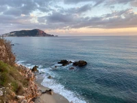 Paisaje marino tranquilo al atardecer con terreno costero