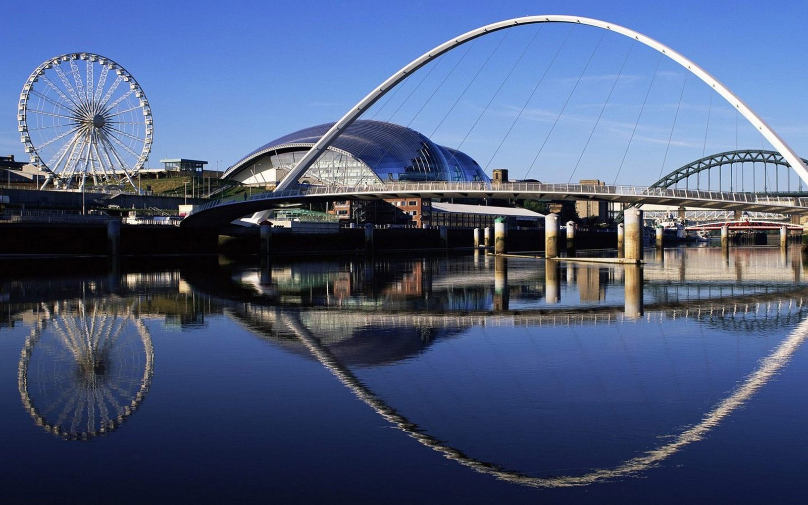 Pont arafed sur un plan d'eau avec une grande roue en arrière-plan (gateshead millennium bridge, pont, rivière tyne, pont en arc, point de repère)