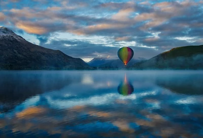 Balão de ar quente colorido sobre o Lago Hayes ao pôr do sol, Queenstown, Nova Zelândia