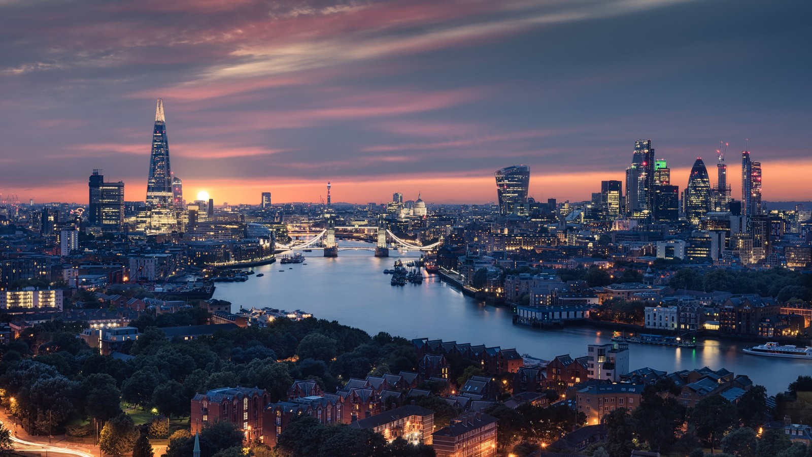 Una vista del horizonte de la ciudad al atardecer con un río que la atraviesa (londres, london, agua, nube, rascacielos)