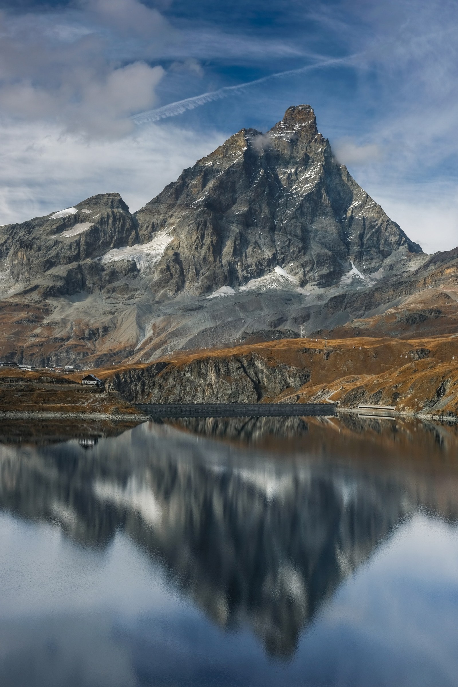 Berge spiegeln sich in einem see mit einem kleinen boot im vordergrund. (berg, gebirgskette, berglandschaft, natur, wolke)