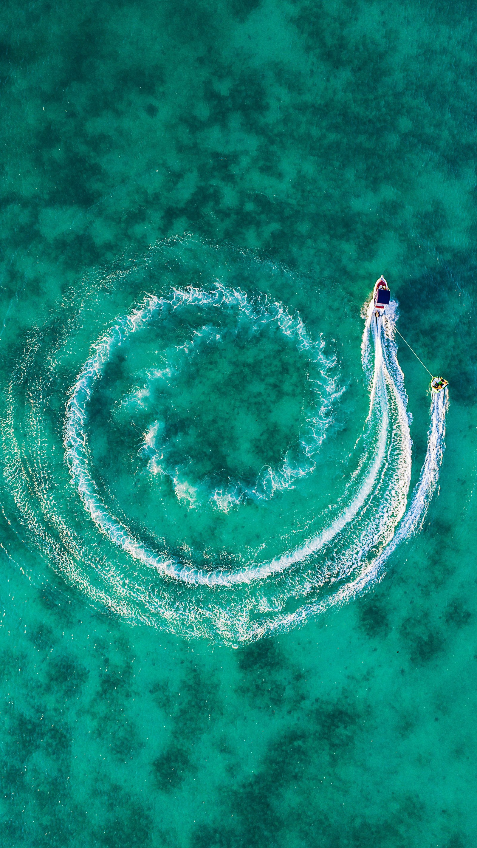 Vue aérienne d'un wakeboarder dans l'océan avec une traînée derrière lui (smartphone, android, eau, ressources en eau, azur)