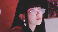 Miyawaki Sakura dans une photo conceptuelle élégante et douce, la présentant avec des cheveux noirs lisses, des lunettes de soleil tendance et des boucles d'oreilles scintillantes.