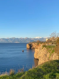 Paisaje costero sereno con montañas y aguas azules