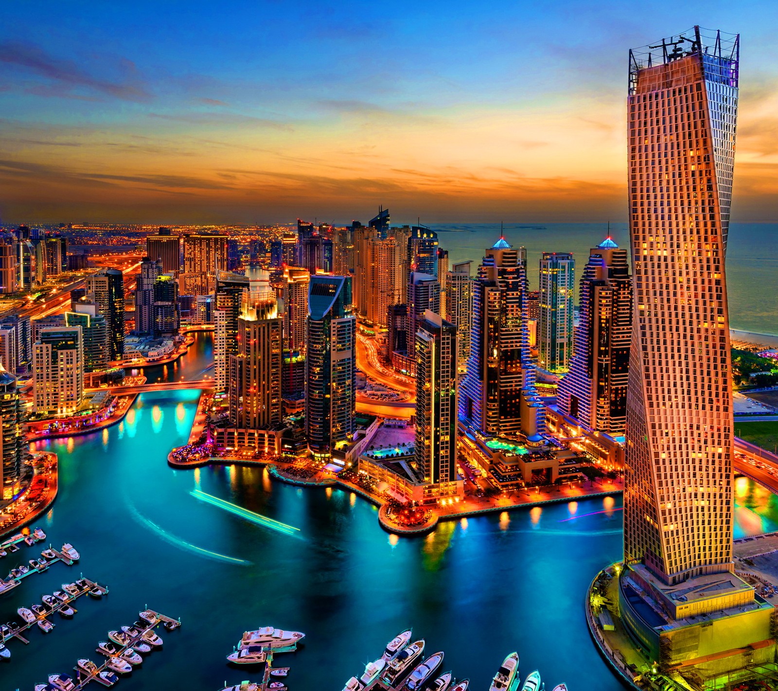 Vue aérienne d'une ville la nuit avec des bateaux dans l'eau (bateaux, ville, dubaï, dubai, port)