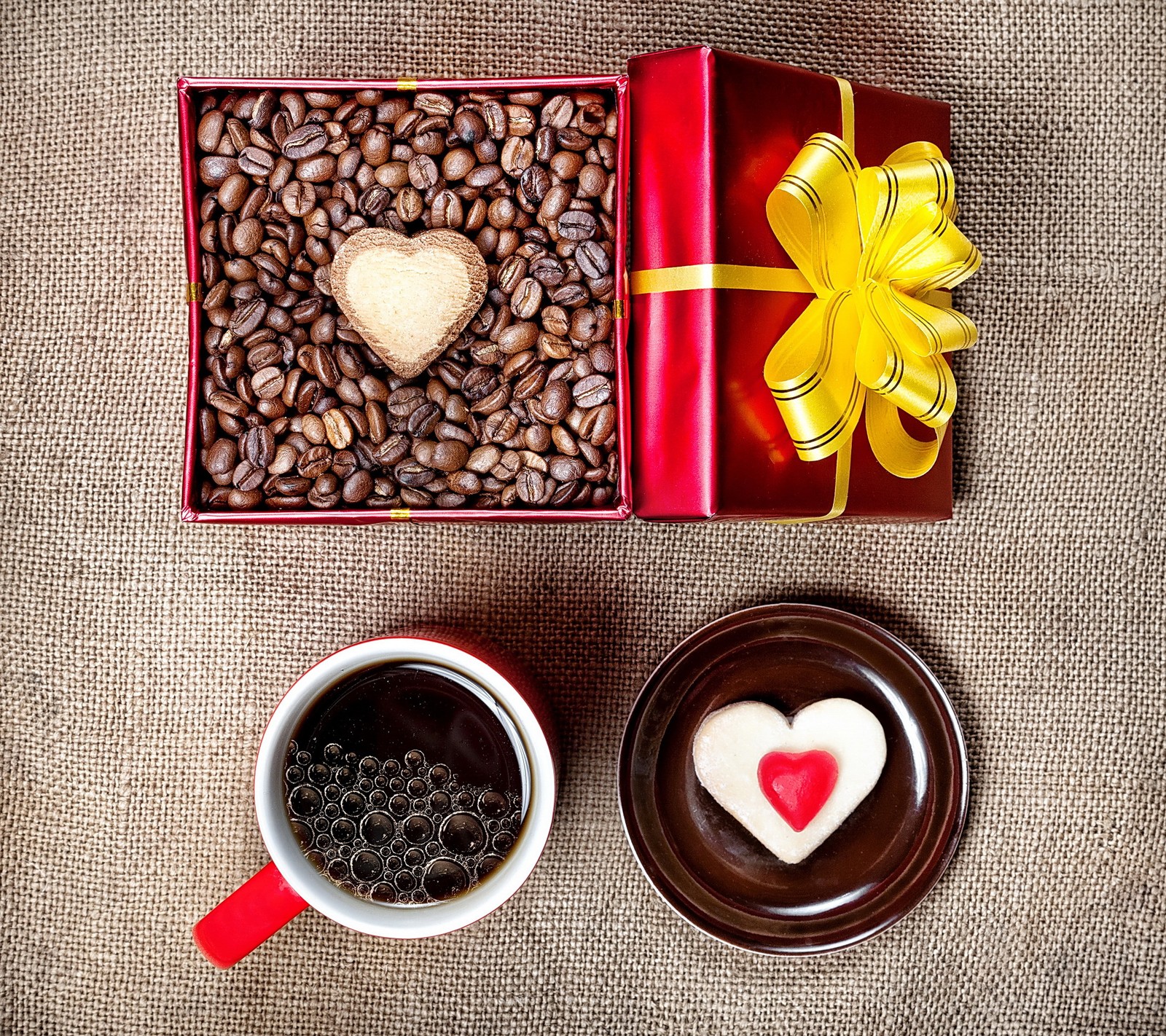 Il y a deux tasses de café et un biscuit en forme de cœur sur la table (haricots, café, cœur, amour)