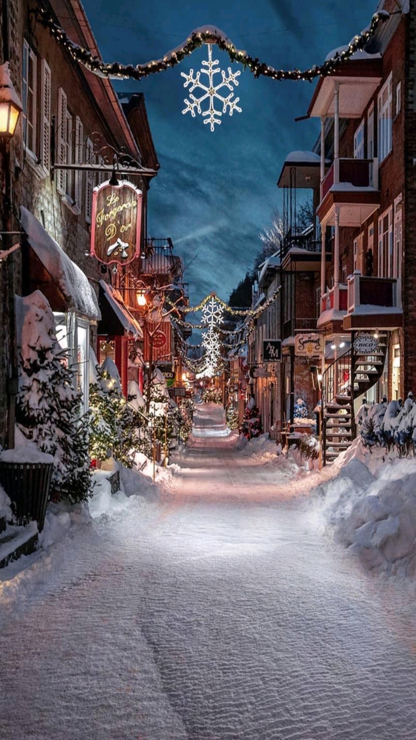 Snowy street with lights and snow covered buildings in the background (christmas, christmas trees, decoration, hd, lights)