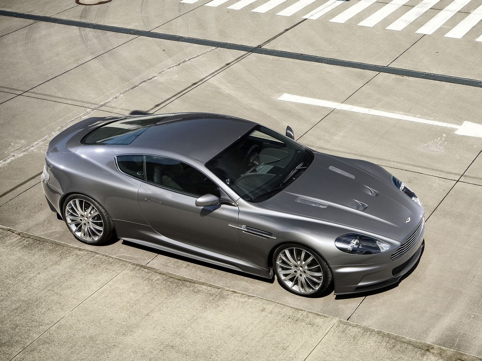 A close up of a silver car parked on a street (aston martin dbs, aston martin vantage, aston martin db9, aston martin dbs v12, aston martin)