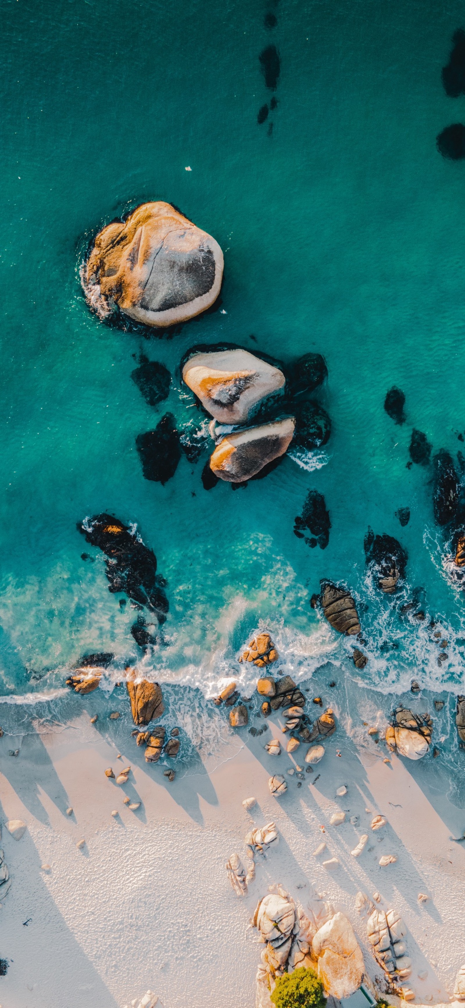 Vista aérea de uma praia com rochas e água e um barco (maçãs, água, aqua, peixe, lazer)