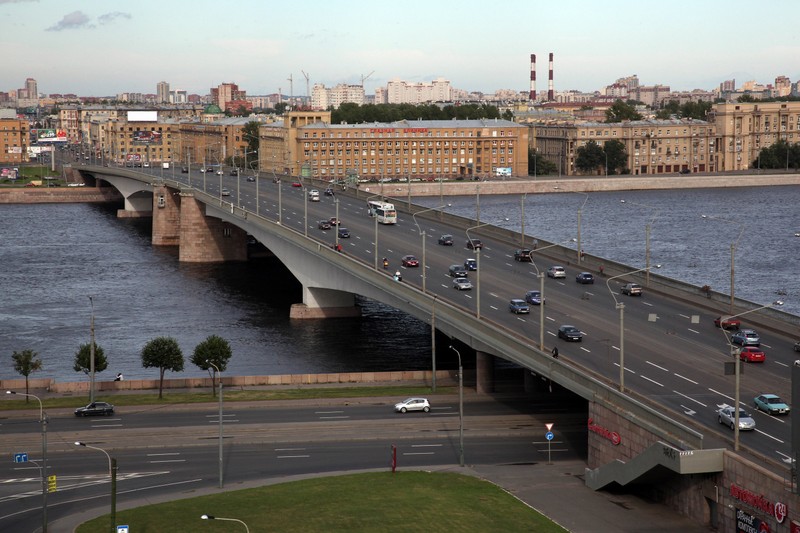 Машины едут по мосту над рекой на фоне города (река нева, мост, подвижный мост, эстакада, небесный путь)