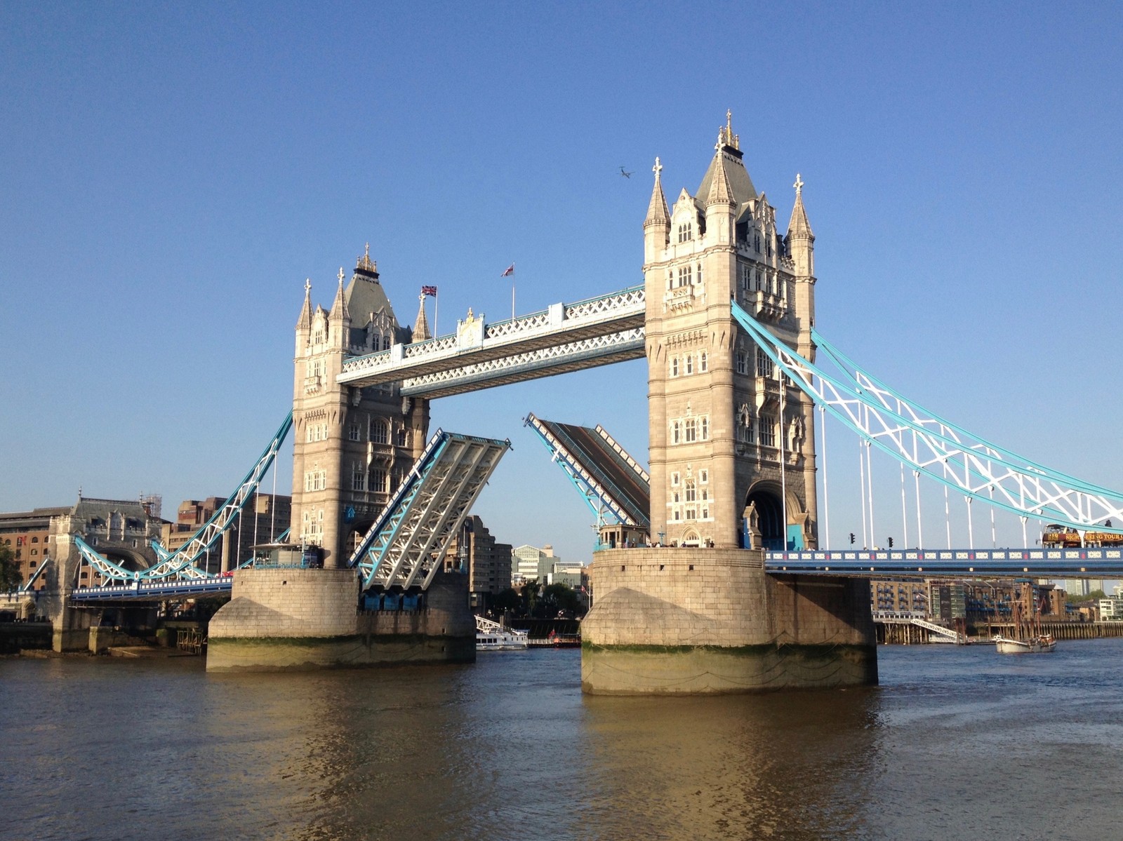 Un pont isolé avec un pont-levis s'ouvrant au milieu de la rivière (tower bridge, pont, point de repère, pont levis, tour)