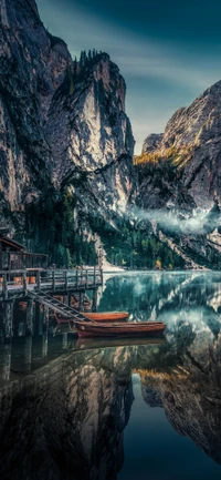 Tranquil Dolomites: Serene Lake with Reflected Peaks and Rustic Boats