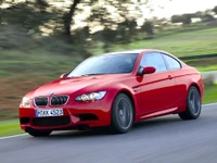 Coupé deportivo rojo BMW M3 E92 en movimiento en una carretera escénica