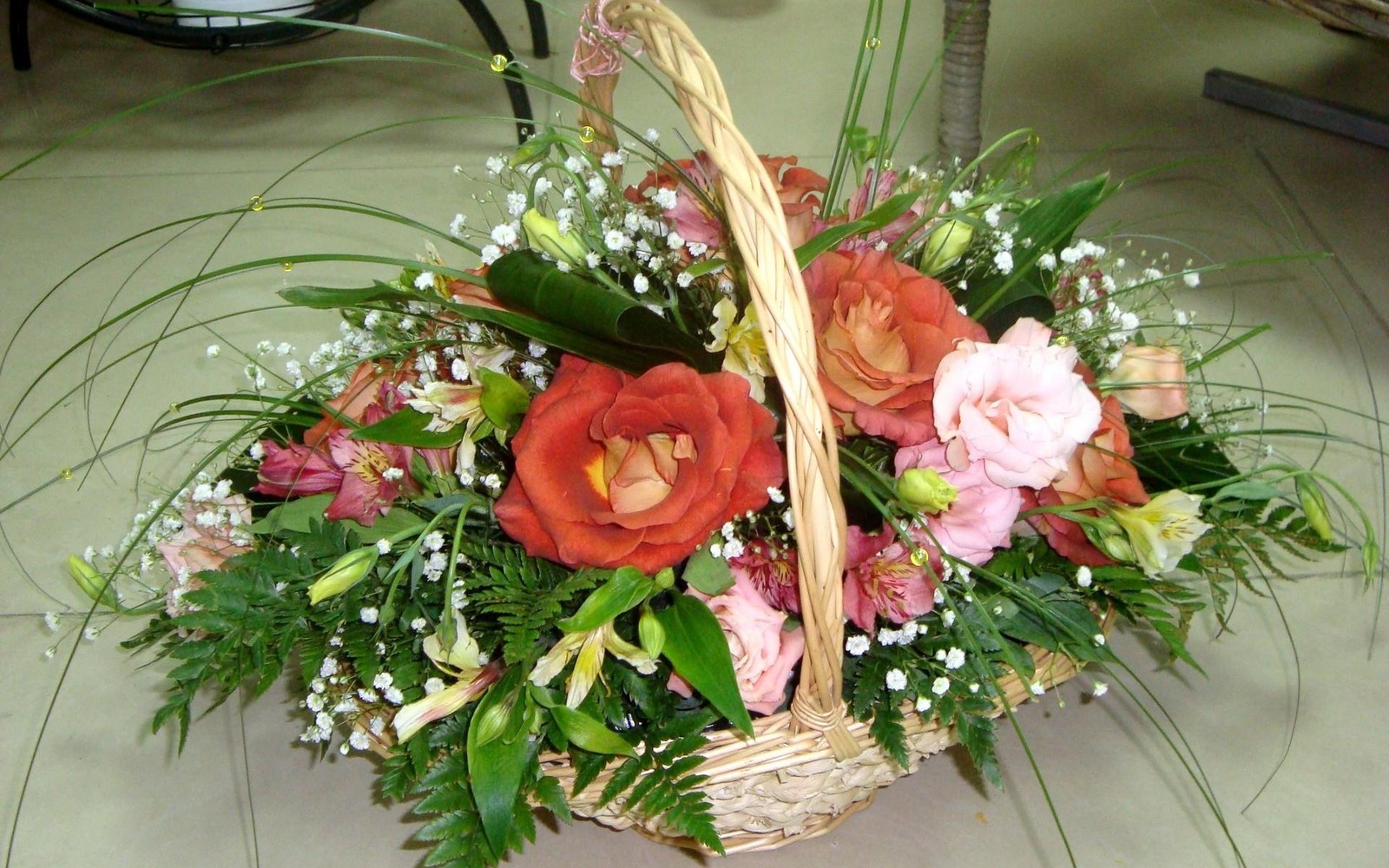 There is a basket with flowers and greenery in it (flower bouquet, floral design, cut flowers, garden roses, ikebana)