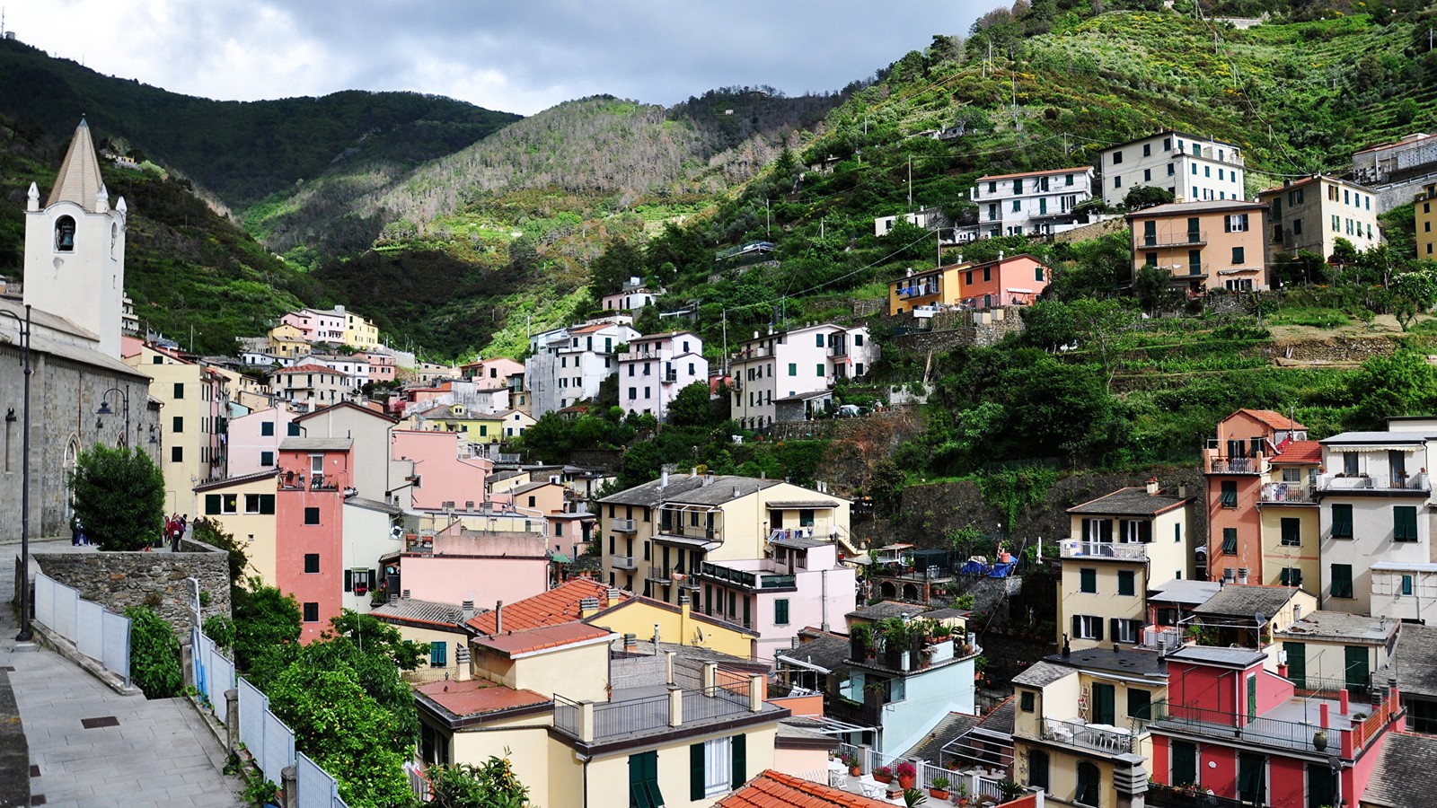 Uma vista de uma cidade com uma colina íngreme ao fundo (montanha, cadeia de montanhas, turismo, aldeia montanhosa, cidade)