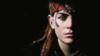 Un portrait frappant d'Aloy, mettant en valeur ses traits de visage uniques, son ornement complexe et ses yeux expressifs sur un fond sombre, incarnant l'essence de la beauté et de la force de Horizon Zero Dawn.