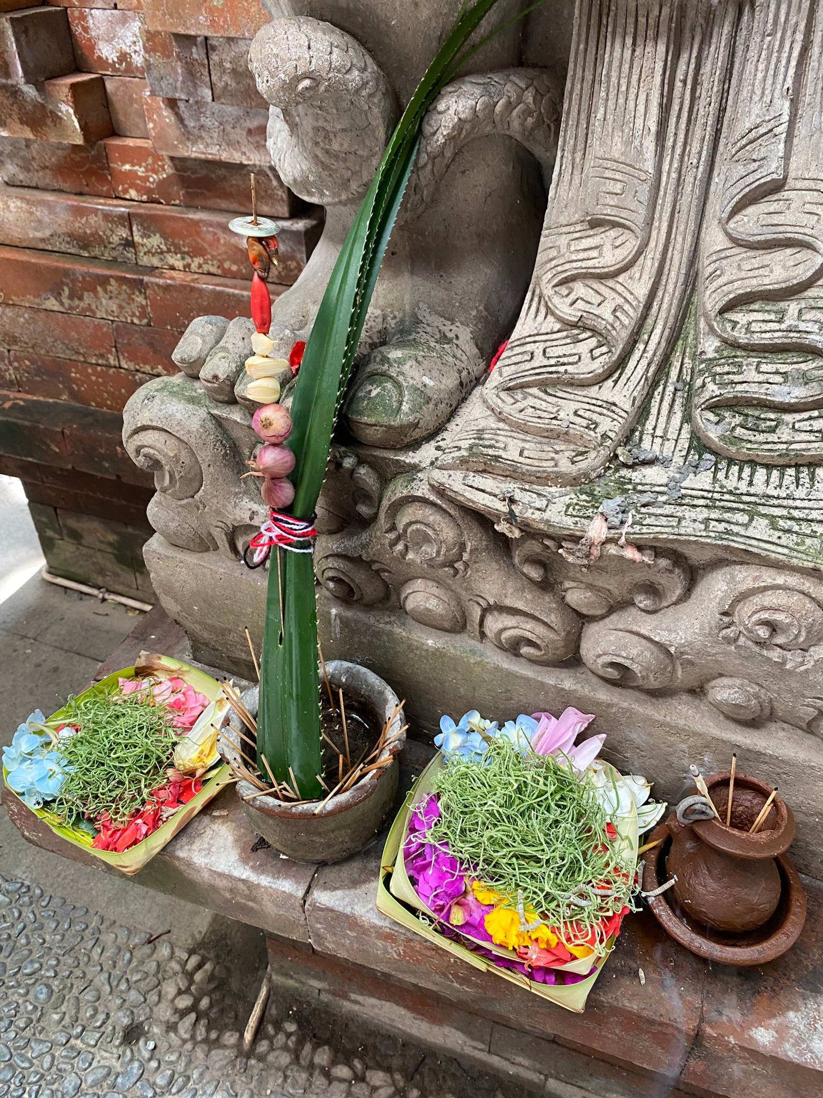 There are two baskets of flowers and a plant on a bench (bali, flower, flowerpot, art, flower arranging)