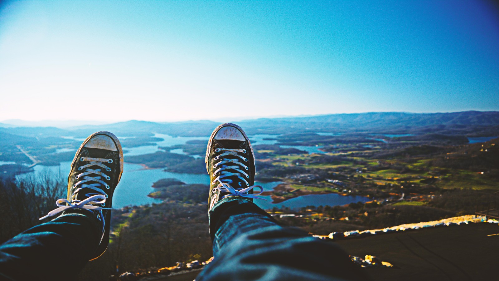 Someone is sitting on a mountain with their feet up (atmosphere, horizon, sunlight, mountain, vacation)