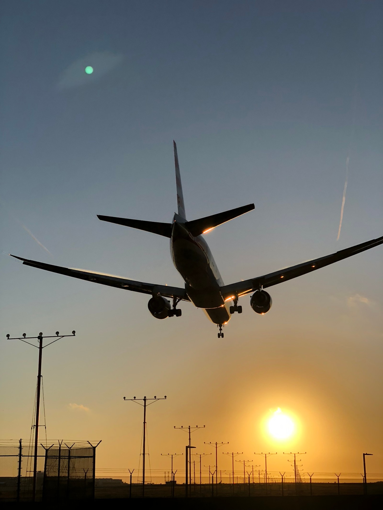 Araflane landing at sunset with the sun setting behind it (airline, boeing 737 next generation, boeing 777, airbus, aircraft)