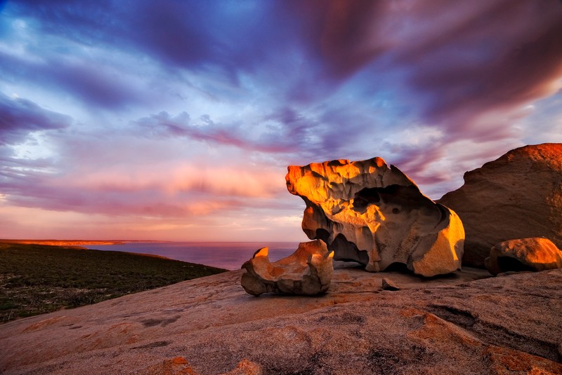 Una gran formación rocosa con un atardecer de fondo. (adelaida, adelaide, roca, nube, formación)