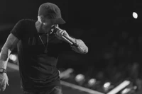 Dynamic black and white performance of a rapper passionately singing into a microphone on stage.