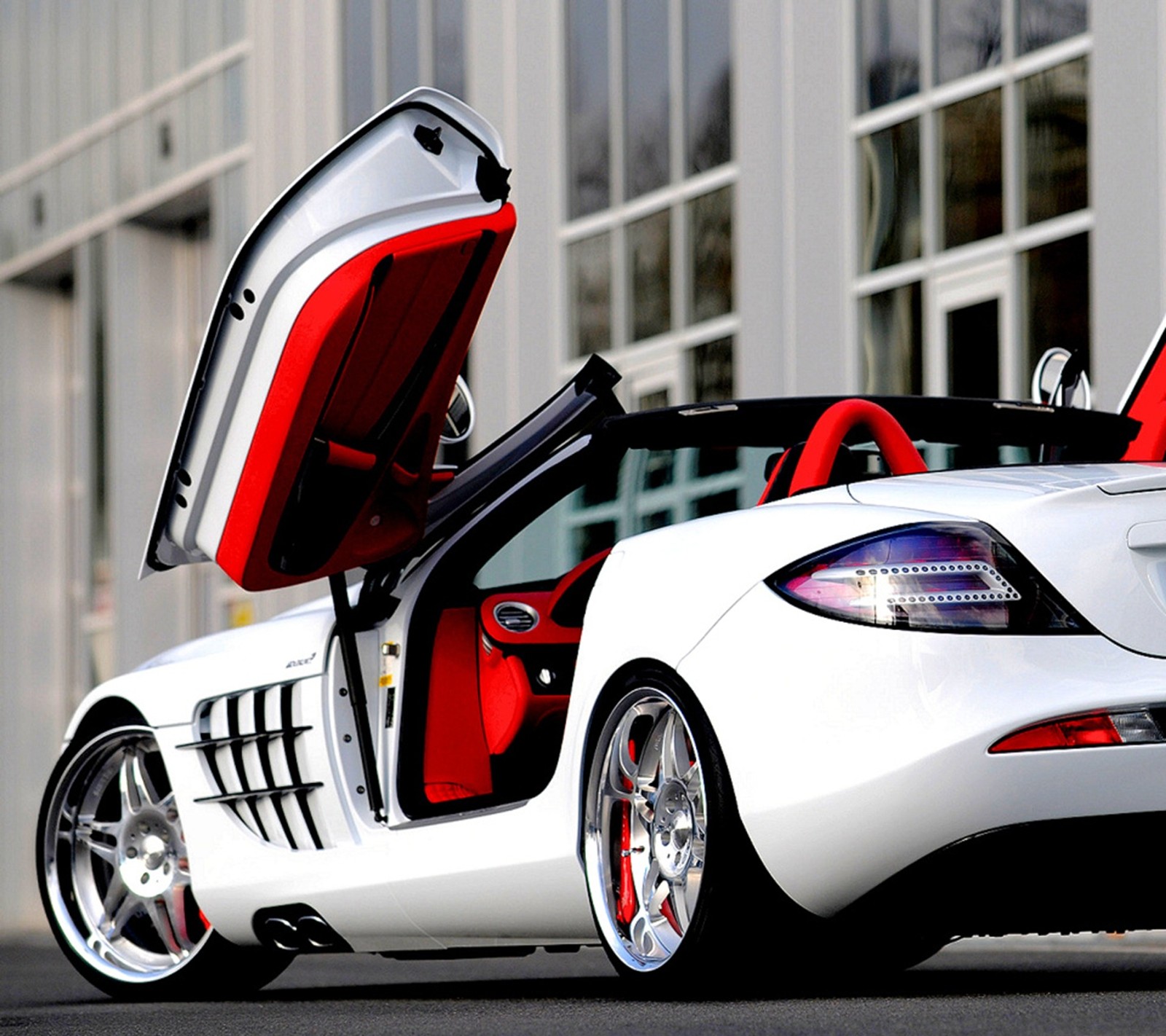 A close up of a white sports car with its doors open (auto, car, classic, cool, mercedes benz)